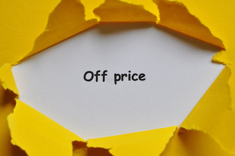 A torn yellow paper background revealing a white card with the words 'Off price' printed in black, situated in a moving and packing context. The image suggests a discount or special offer related to house removals or moving services. The yellow paper's edges are jagged, emphasizing the uncovering of the message, with the setting indicating packaging or promotional material associated with [COMPANY_NAME]’s relocation or furniture transport services. The lighting is even, highlighting the contrast between the yellow background and the white card, and the focus is sharp on the text, making the message clear and easily readable for accessibility purposes.