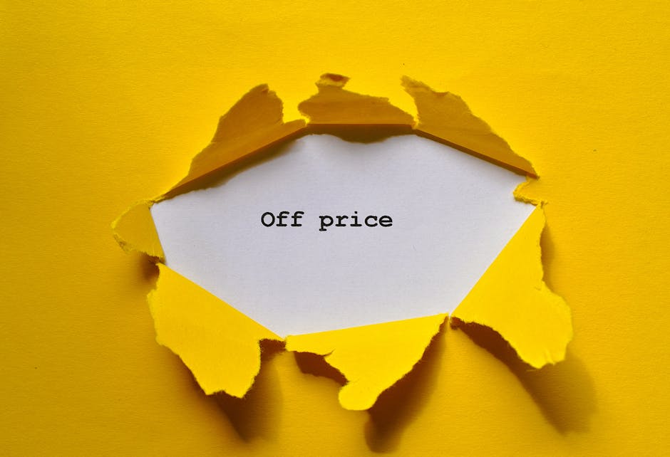 A bright yellow paper surface with a large, irregularly torn hole revealing a white paper sheet underneath, on which the words 'Off price' are printed in black text. The torn edges of the yellow paper have a rough texture and cast subtle shadows, creating a sense of depth. This image captures a visual representation of a reveal or discount concept, with the torn paper symbolising a reduction or special offer. It is set in a well-lit environment, emphasizing the contrast between the yellow background and the white sheet. The scene relates to packing or moving contexts by demonstrating packaging materials and the idea of revealing or uncovering items, aligning subtly with the themes of home relocation and furniture transport handled by companies like Man with Van Surbiton.